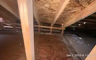 Attic space with wooden beams and flooring.