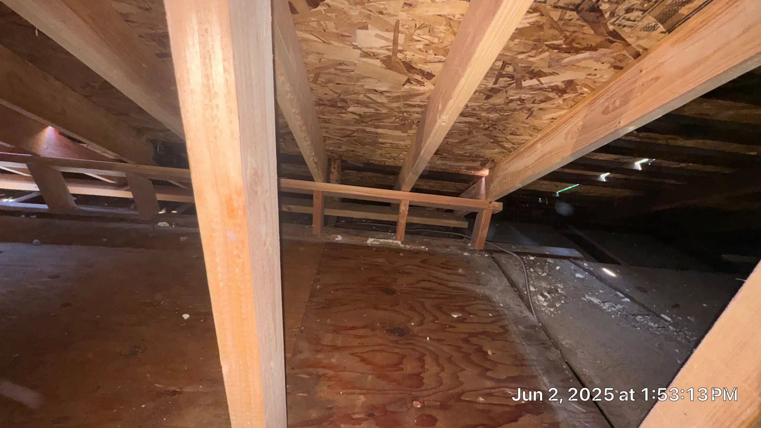 Attic space with wooden beams and flooring.