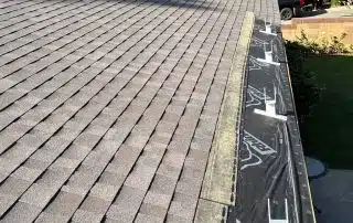 Roof installation with scenic background trees.