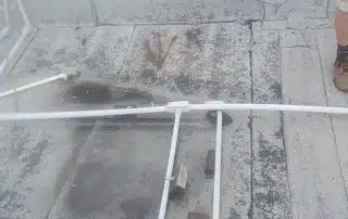 Rooftop with pipeline and damaged surface.
