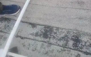 Person on roof with sneakers and pole