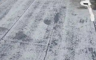 Flat roof with patched areas.
