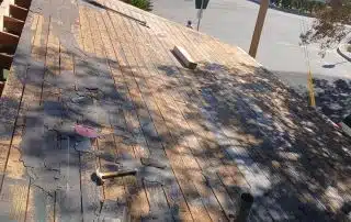 Partially removed roof shingles with visible roof structure.