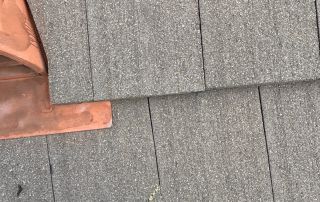 21-Feb 12 2026 03_22pm-25w5 Person standing on shingled roof near chimney flashing.