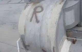 Rooftop duct with graffiti arrow and 'R' letter.