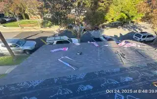 Shingle roof repair with tools and materials visible.