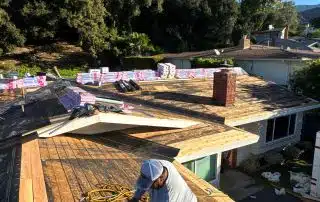 Construction worker roofing a house with tools.