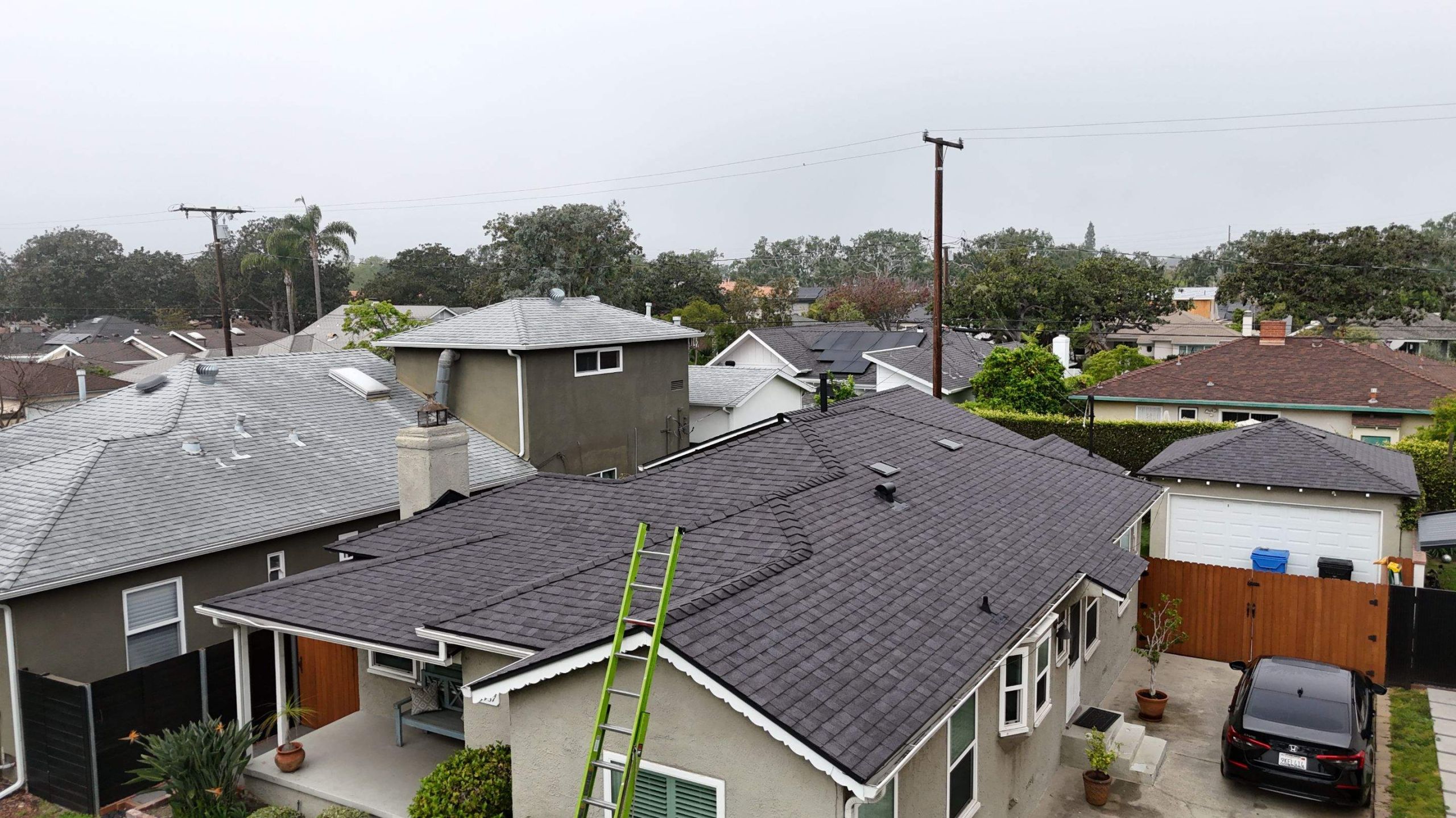 Suburban homes with gray roof and ladder