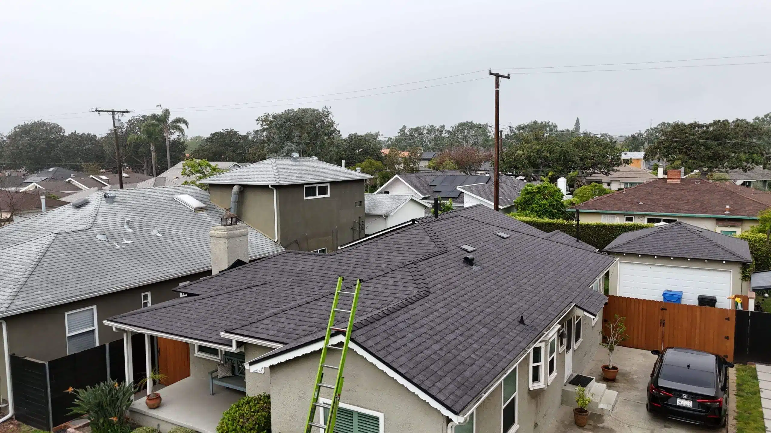 Suburban homes with gray roof and ladder