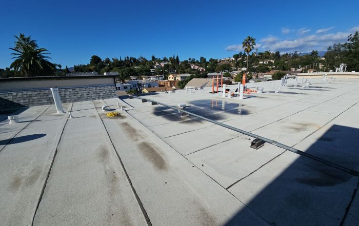 Flat rooftop with vents overlooking hillside neighborhood