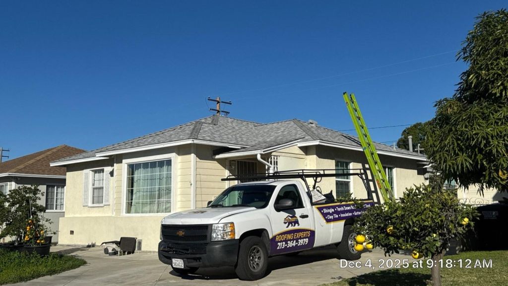 Freshly installed galvanized steel roof flashing around a chimney base on a Southern California residential roof