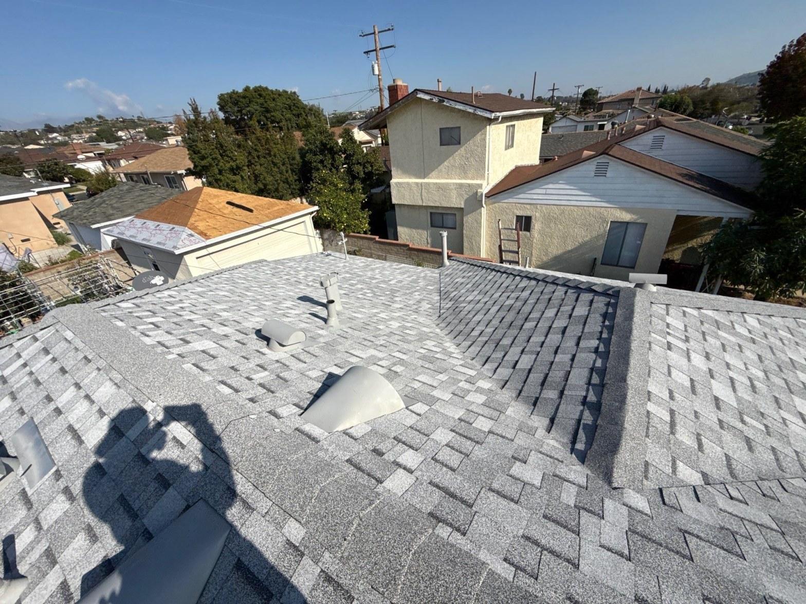 Corroded step flashing at chimney base showing rust streaks and lifted metal edges on a Southern California residential roof