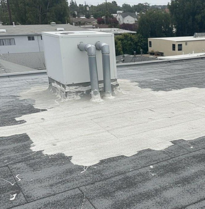 emergency-roof-repair-flat-roof-water-patch-los-angeles Flat roof with emergency sealant worked around a rooftop unit and its pipe penetrations to stop water entry