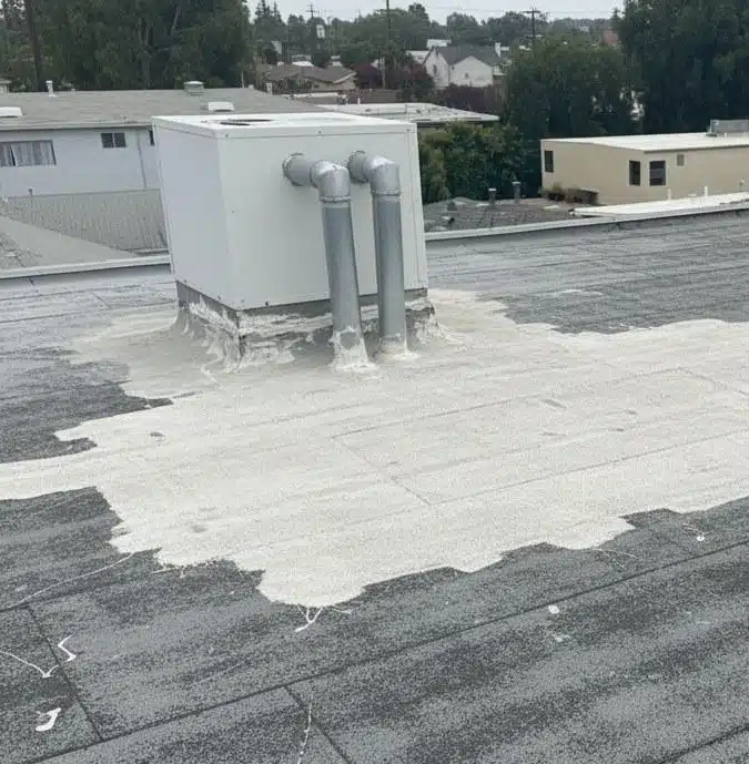 emergency-roof-repair-flat-roof-water-patch-los-angeles Flat roof with emergency sealant worked around a rooftop unit and its pipe penetrations to stop water entry
