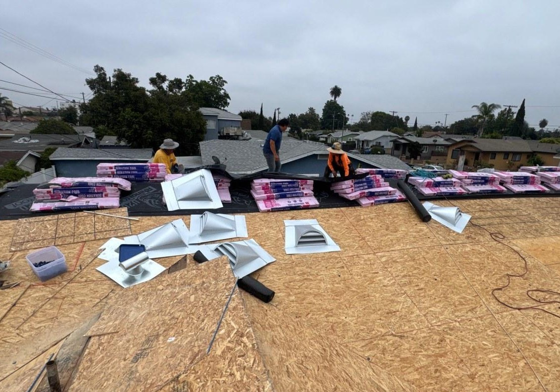 emergency-roof-repair-roof-stripped-to-decking-los-angeles Roof stripped back to bare decking with replacement roofing material and vents staged along the ridge