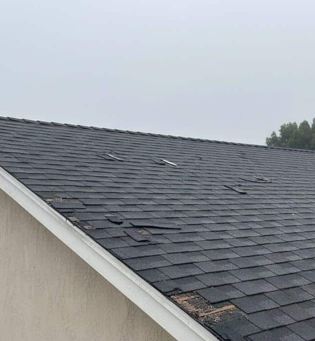 Storm damaged shingle roof needing emergency repair
